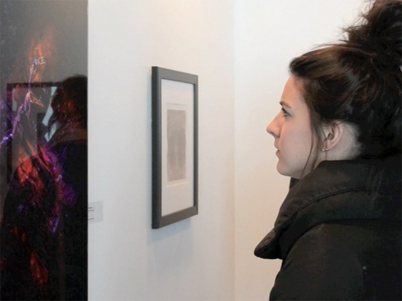 A person looks at pieces on display at Exposure HQ at the 2018 Exposure Photography Festival