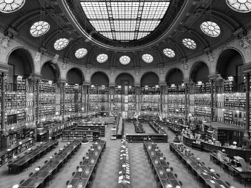 A black and white photo of a grand library.