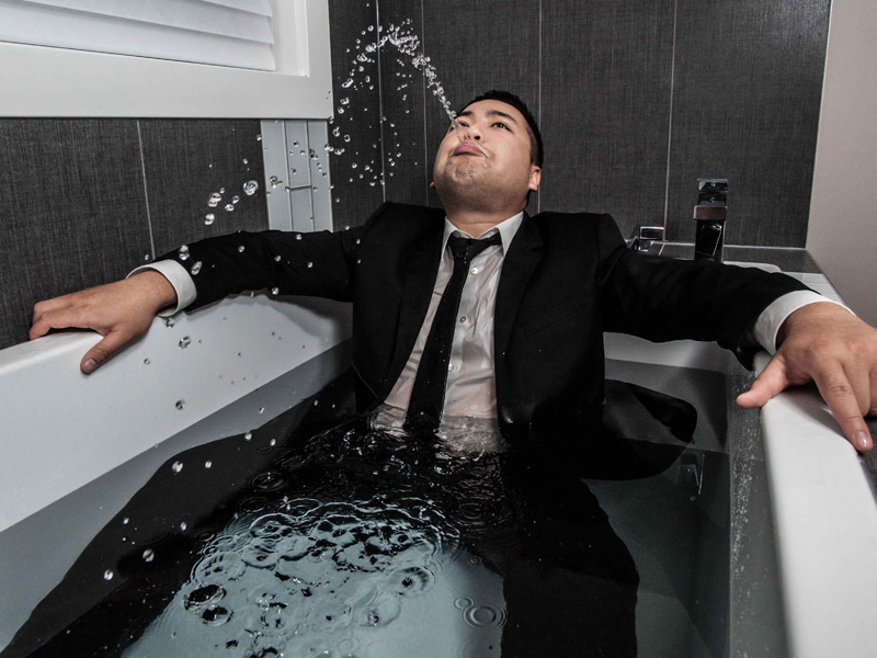 Photo of Andrew Phung in a bathtub wearing a suit