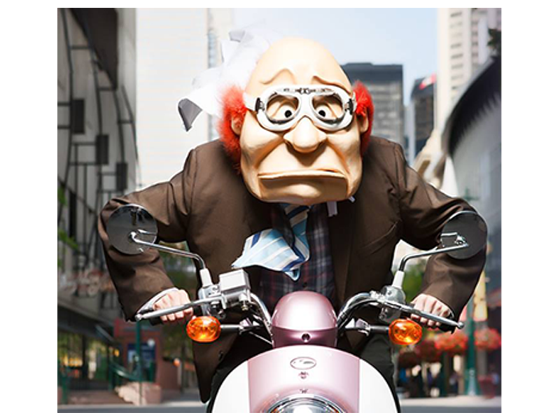 A puppet of an elderly man on a motorcycle