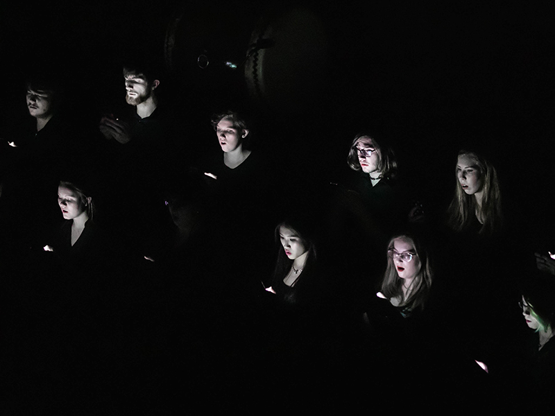 Photo of Mount Royal Artio singing with lights illuminating their faces