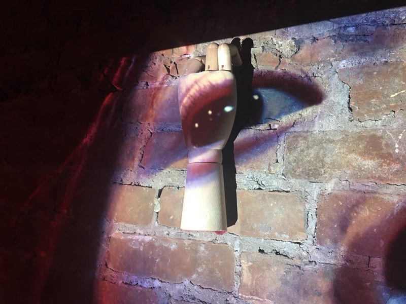 Photo of a projection of an eye on a brick wall