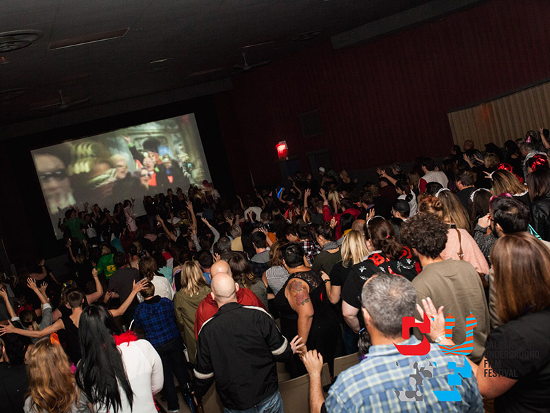 Audience members stand up and dance at the Calgary Underground Film Festival, Calgary Queer Arts Society, and Hole in the Wall Studios screening