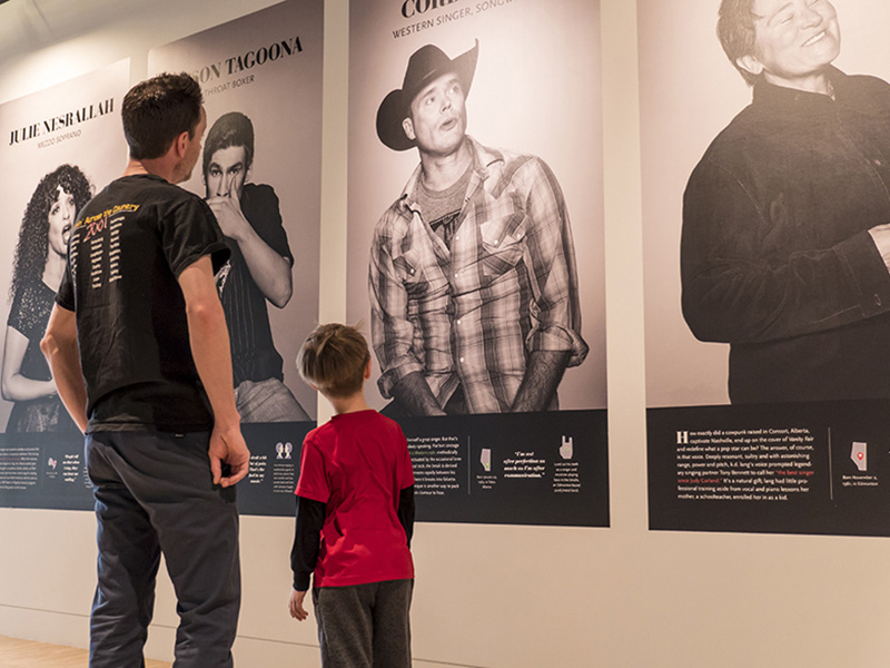 A man and a child look at a display featuring Albertan artists at the National Music Centre