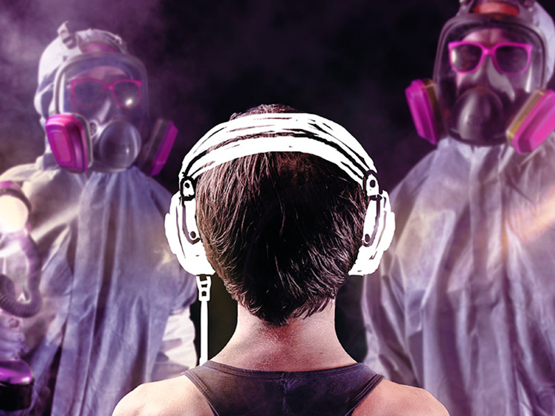 A person with headphones looks towards two people unrecognizable in paint masks and smocks