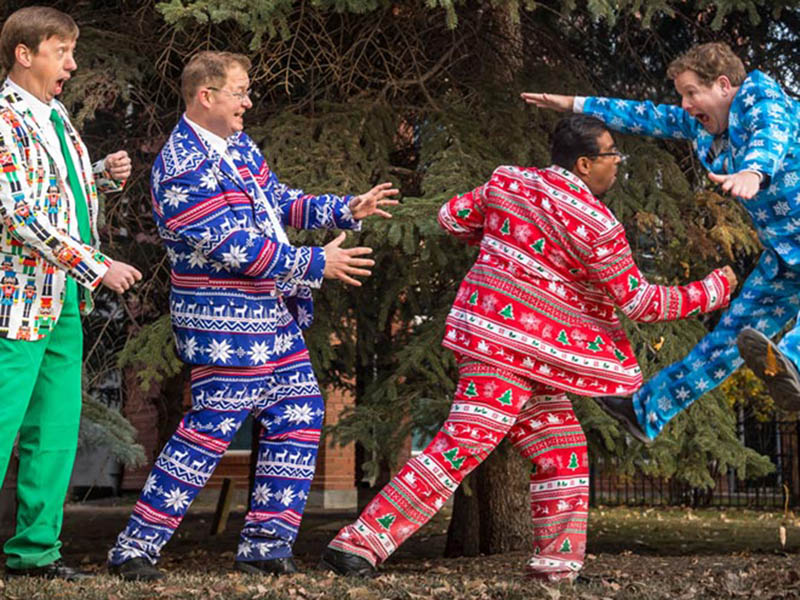 The Heebee-jeebees mock fight while wearing colourful Christmas suits