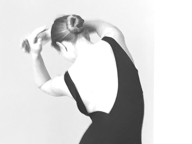 A black and white photo of a dancer's curved back
