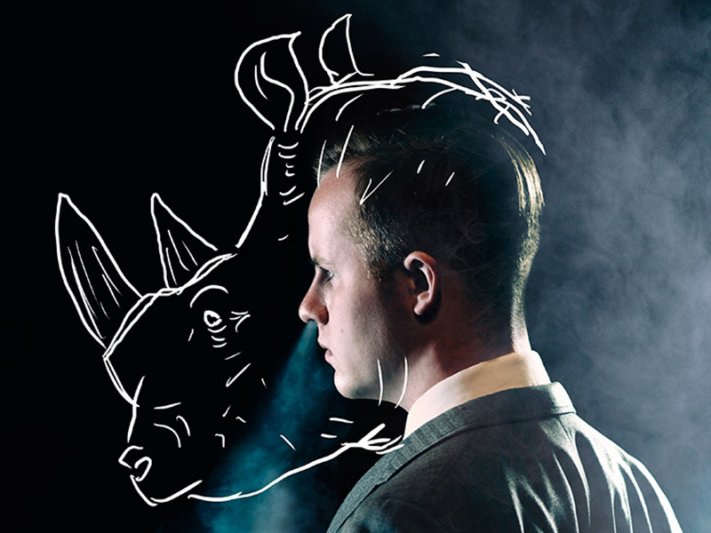 A promo image from Rhinoceros with a man's profile with a rhinoceros head sketched over it