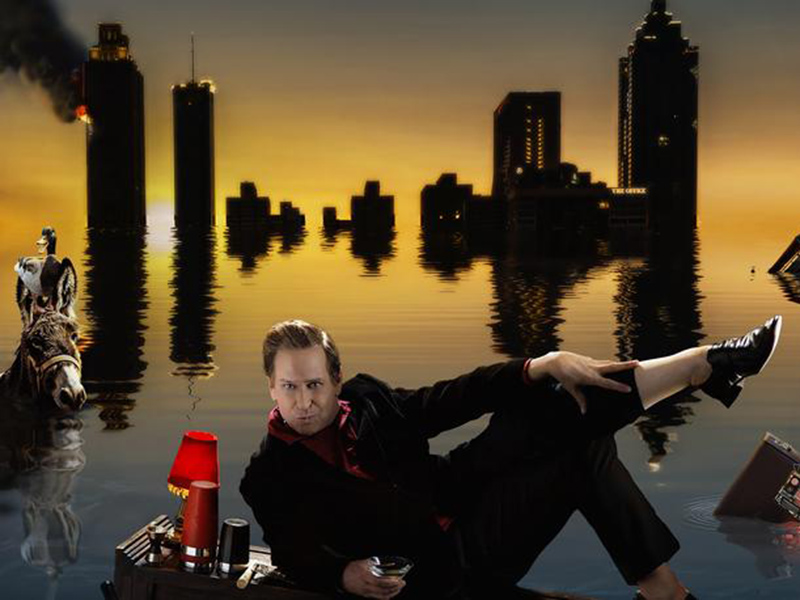 A graphic of Buddy Cole lounging in front of a flooded skyline