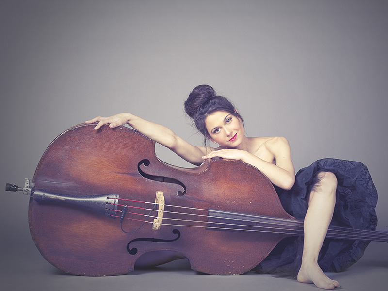 A photo of Brandi Disterheft leaning on her bass