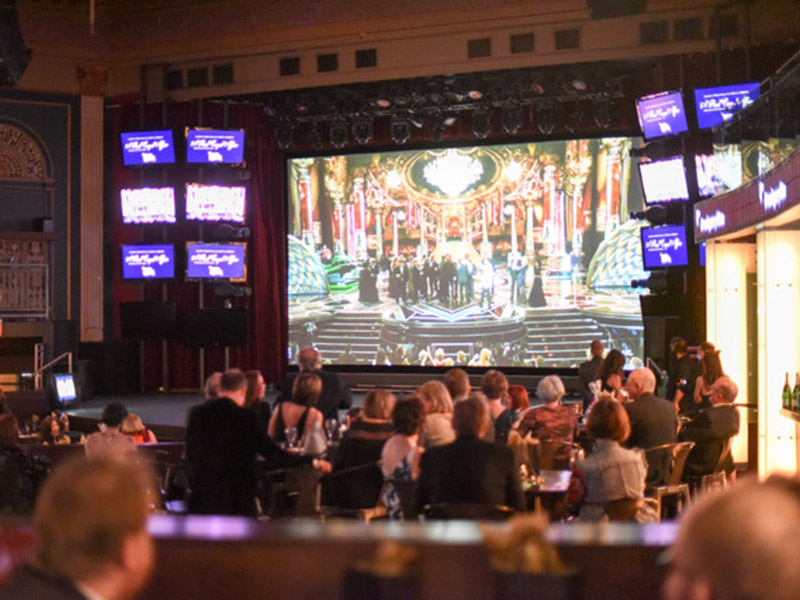 The audience watches a live stream of the Oscars at The Palace Theatre for A Red Carpet Affair