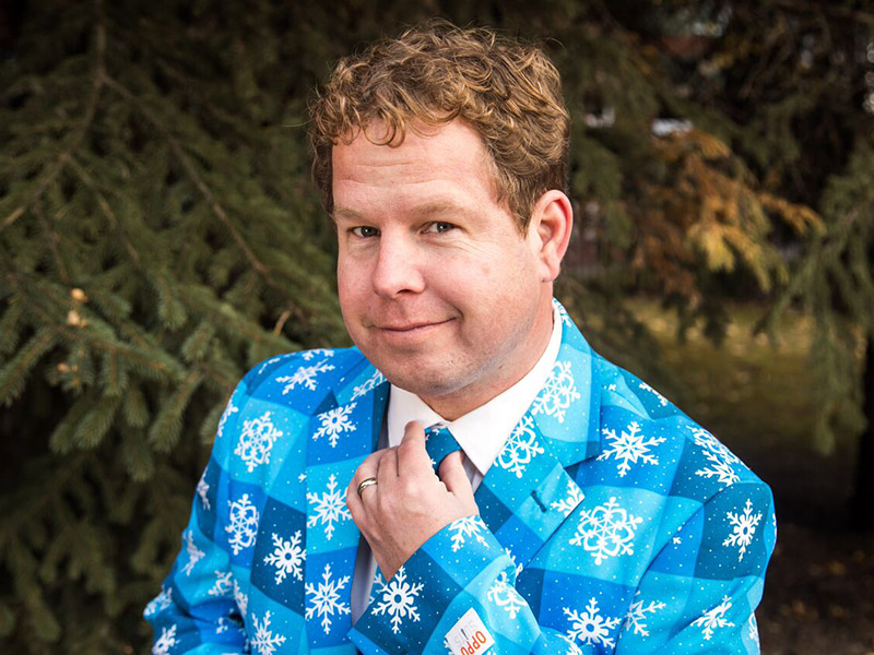 Jonathan Love wears a bright blue suit covered in snowflakes