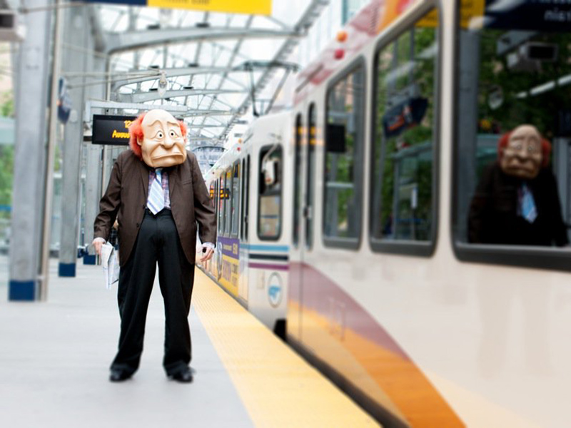 A puppet fellow waits on the CTrain platform as a train goes by