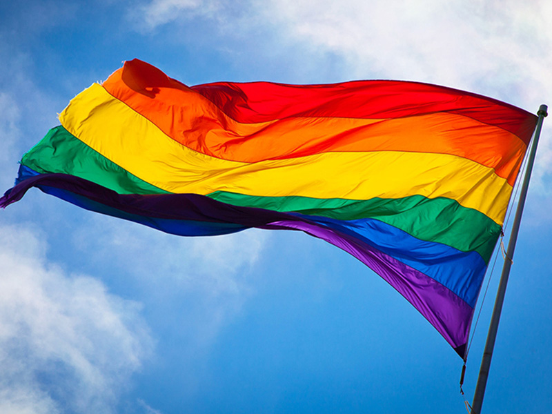 A photo of a flying rainbow flag