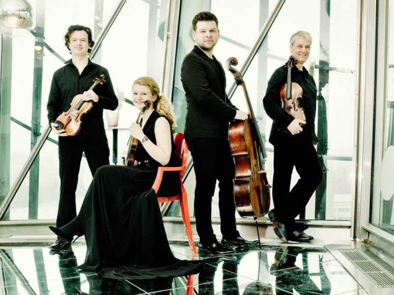 A promotional photo of the Pavel Haas Quartet with their instruments