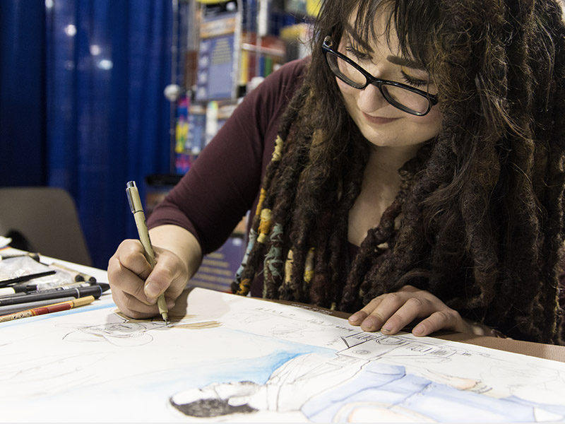 An artist draws in the Calgary Comic & Entertainment Expo's Artist Alley
