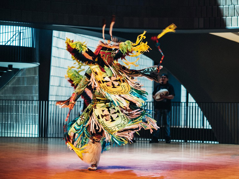 An Indigenous dancer performs in full regalia