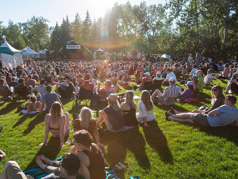 Audience members sit on the grass at the Calgary Folk Music Festival