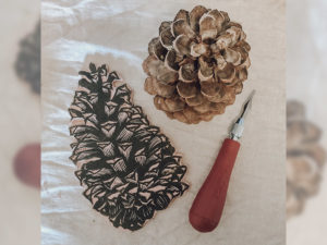 A llino block carving, tool, and pine cone