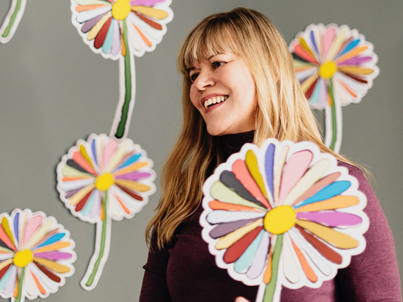 A photo of Shelley Youngblut with paper daisies