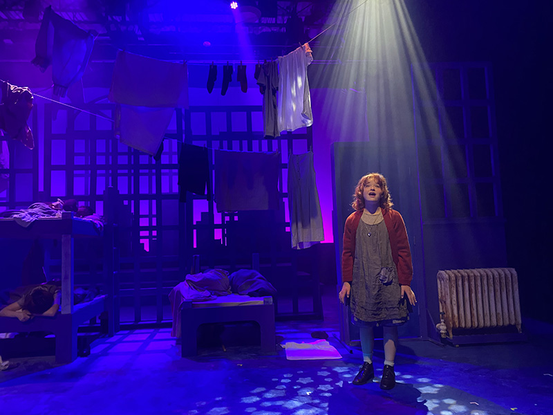 Alexa Andrews on stage as Annie