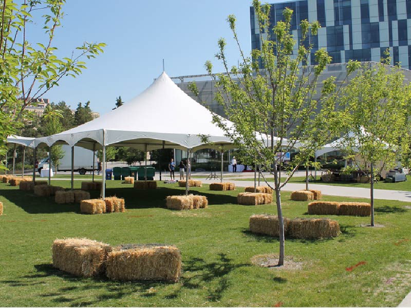 Image of a white tent and hay bales set up in the TFDL quad at the University of Calgary