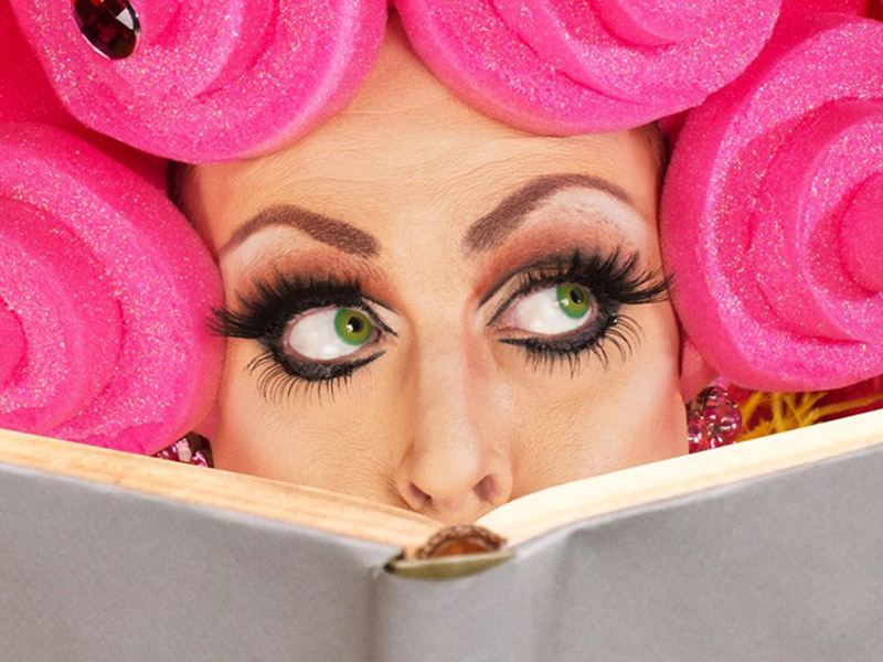 A drag queen reading a book