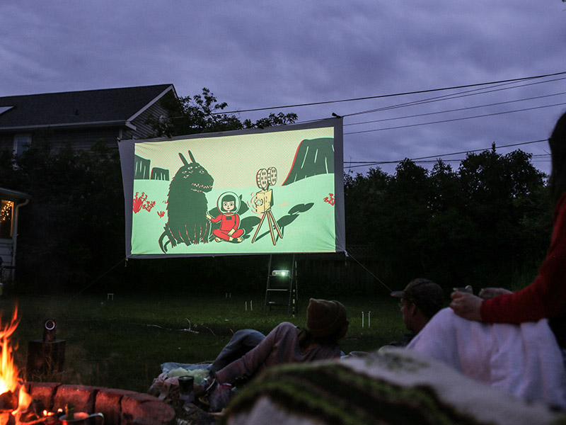 People enjoying a CUFF screening in their backyard with a fire