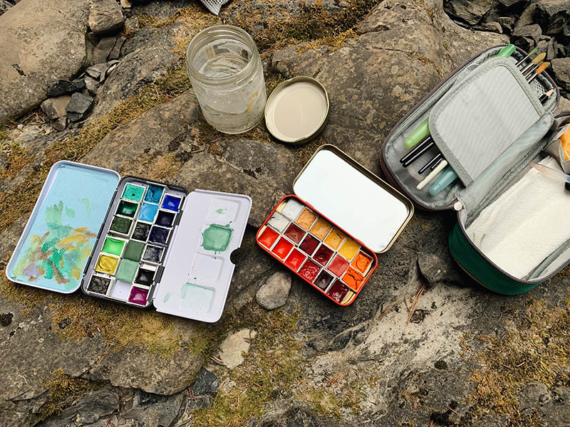A photo of painting tools sitting on rocks
