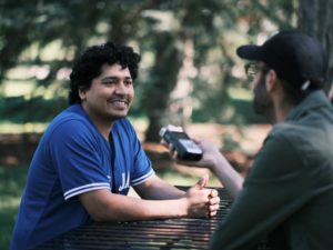 An image of man being interviewing at picnic table