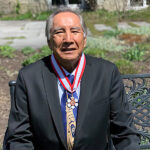 An image of Dr. Leroy Little Bear sitting on a bench