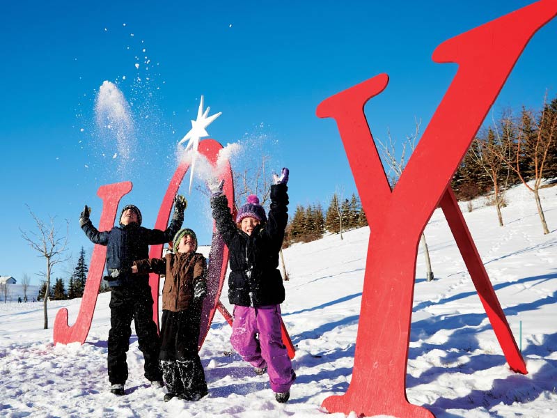 Image of kids throwing snow in front of a sign that reads JOY