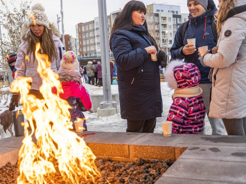 Image of firepit with people gathering around it at University District