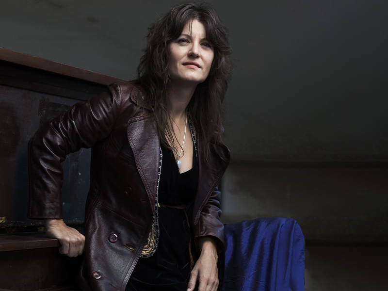 An image of Kenna Burima in a leather jacket against a dark background