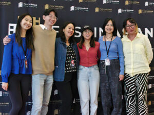 A photo of six people standing side by side