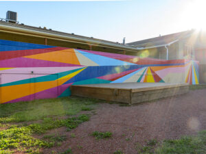 A mural filled with colourful lines create an abstract landscape.