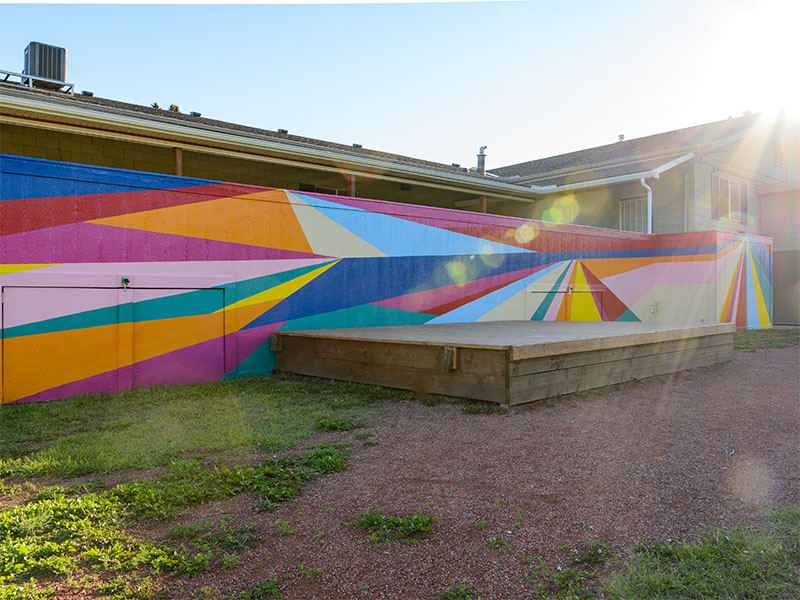 A mural filled with colourful lines create an abstract landscape.
