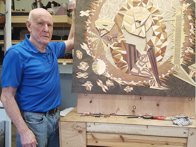 An image of Martin Askew with a wood art painting