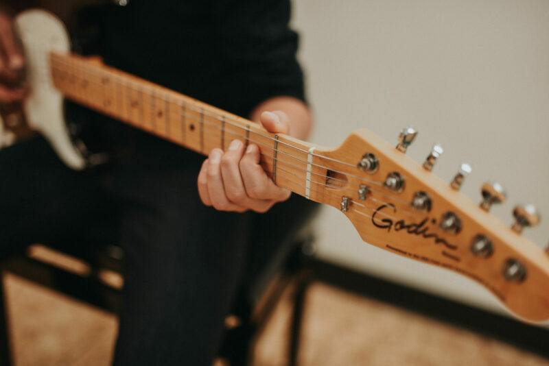 Photo of a person playing an electric guitar.