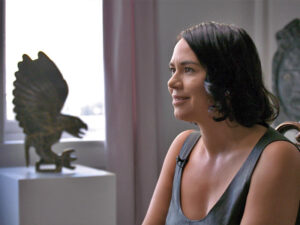 An image of Sophia Lebessis in profile with a piece of Inuit art beside