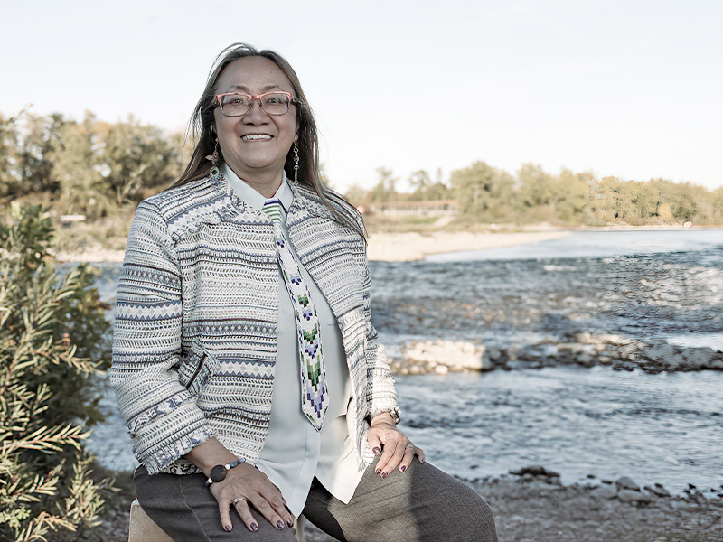 An image of Patti Pon standing beside a river