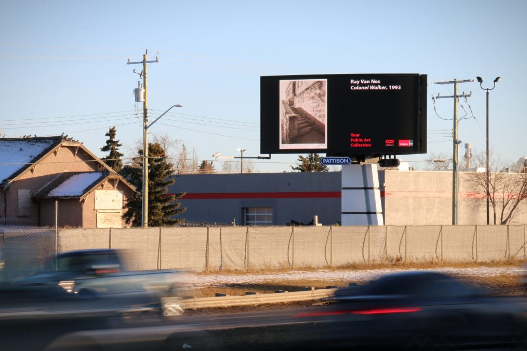 A billboard featuring a work from the city public art collection, shown next to a road through a neighbourhood.