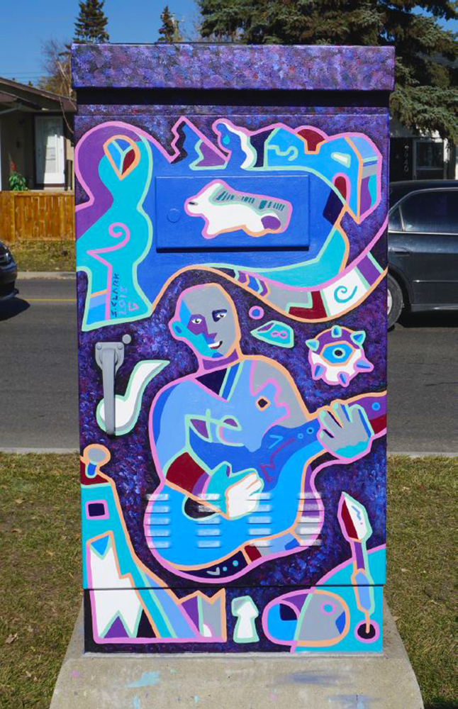 A utility box wrapped with artwork of a musician strumming a guitar, in shades of blue