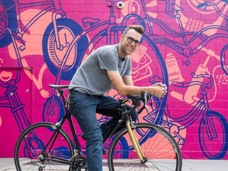 Person on bike in front of mural
