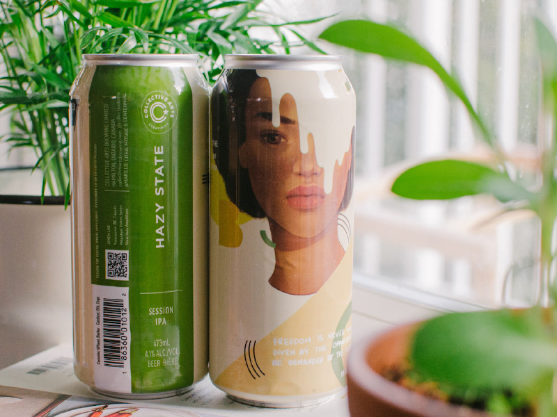 Two tall cans, one with artwork of a woman