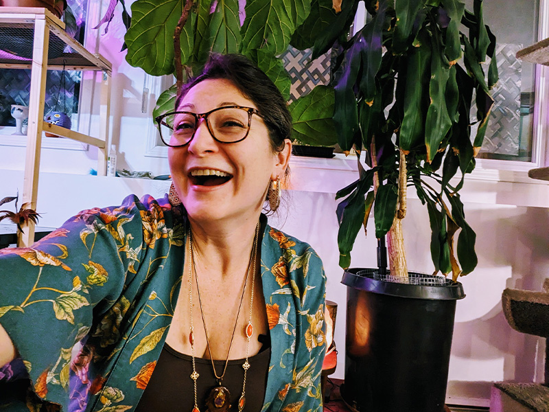 Stacey Perlin laughing next to a plant
