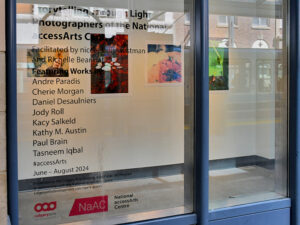Artworks behind glass from the exhibit Storytelling Through Light: Photographers of the National accessArts Centre