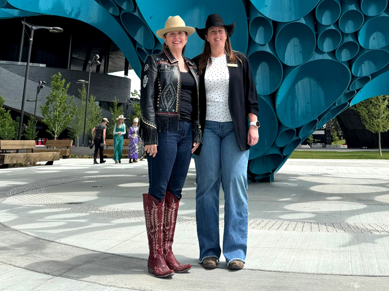 Kerri Souriol and Jill Cross standing in front of the artwork Spirit of Water at the BMO Centre