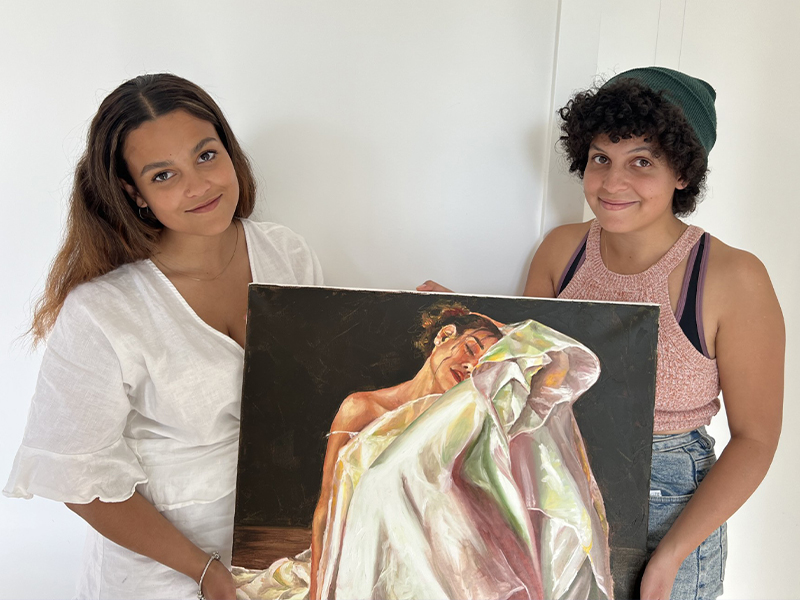 Rebbekah Ogden and Laura Vaughters holding a portrait