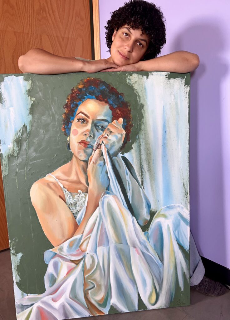 Photo of artist standing over their self portrait painting